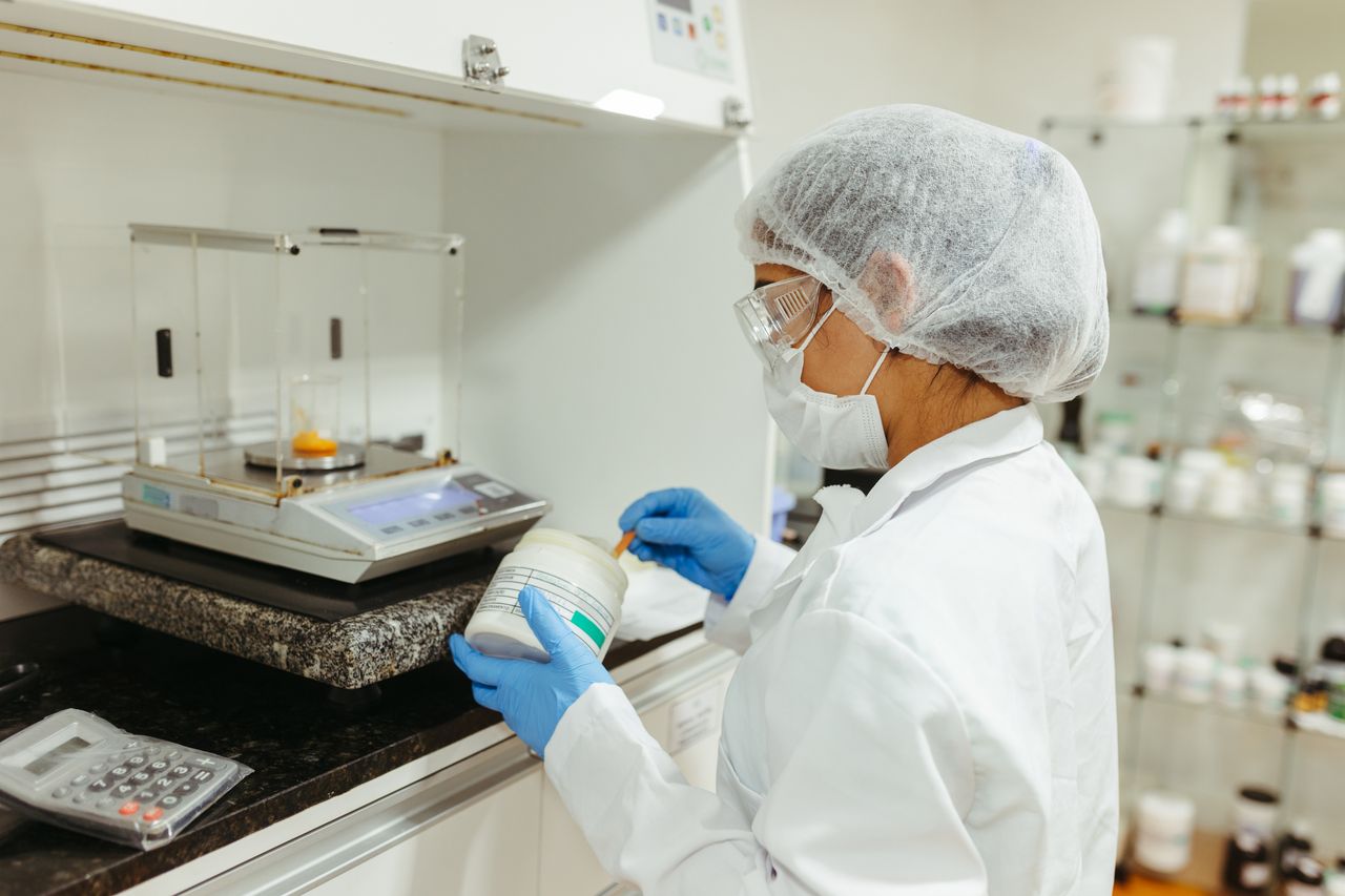 A scientist in a lab coat conducts an experiment in a laboratory, showcasing precision and safety protocols.